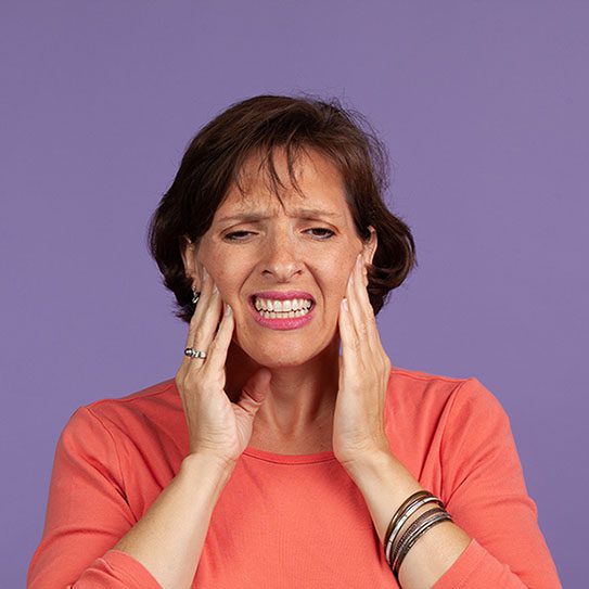 Woman holding in jaw in pain